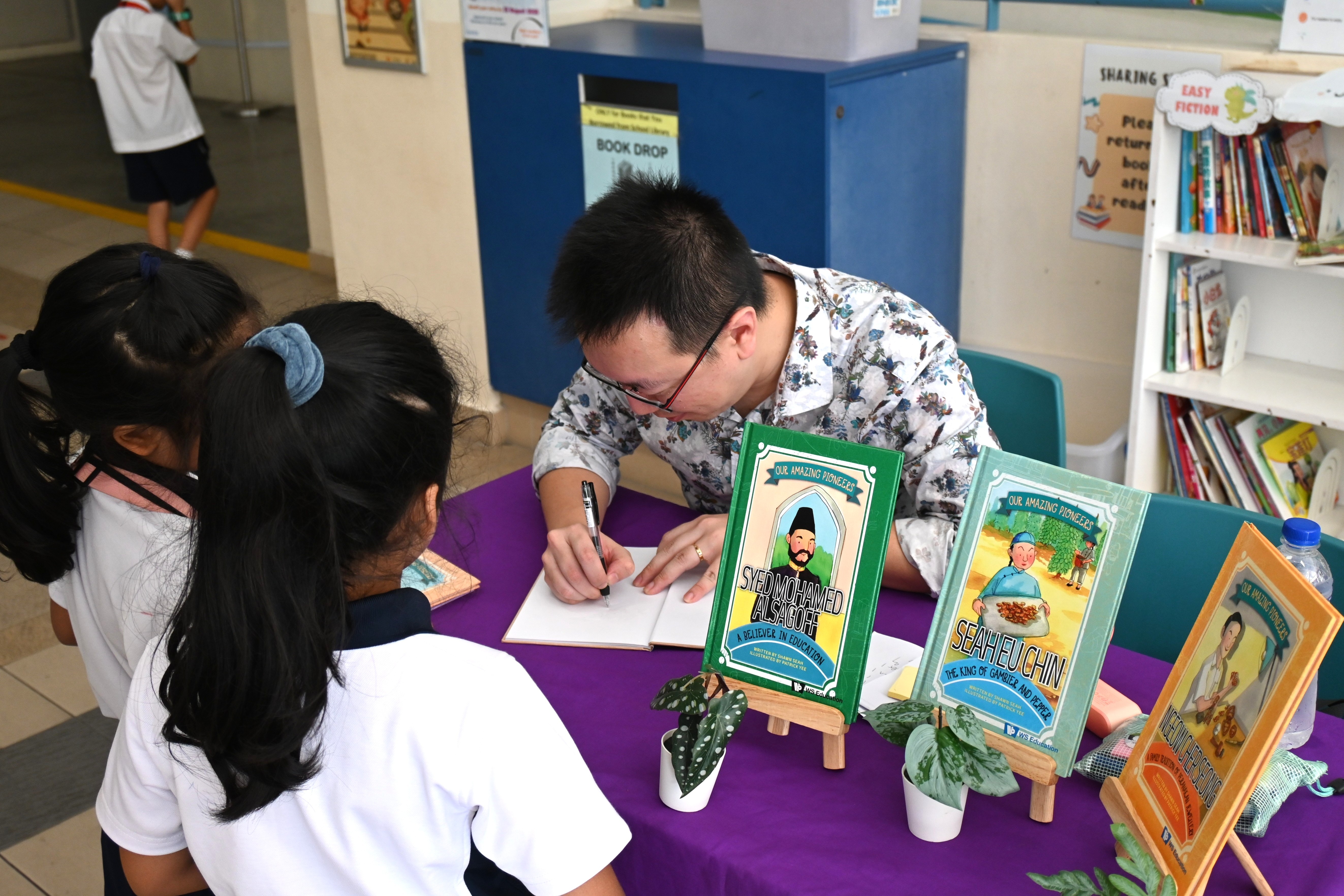 Author Shawn Seah autographing books for primary school pupils. 