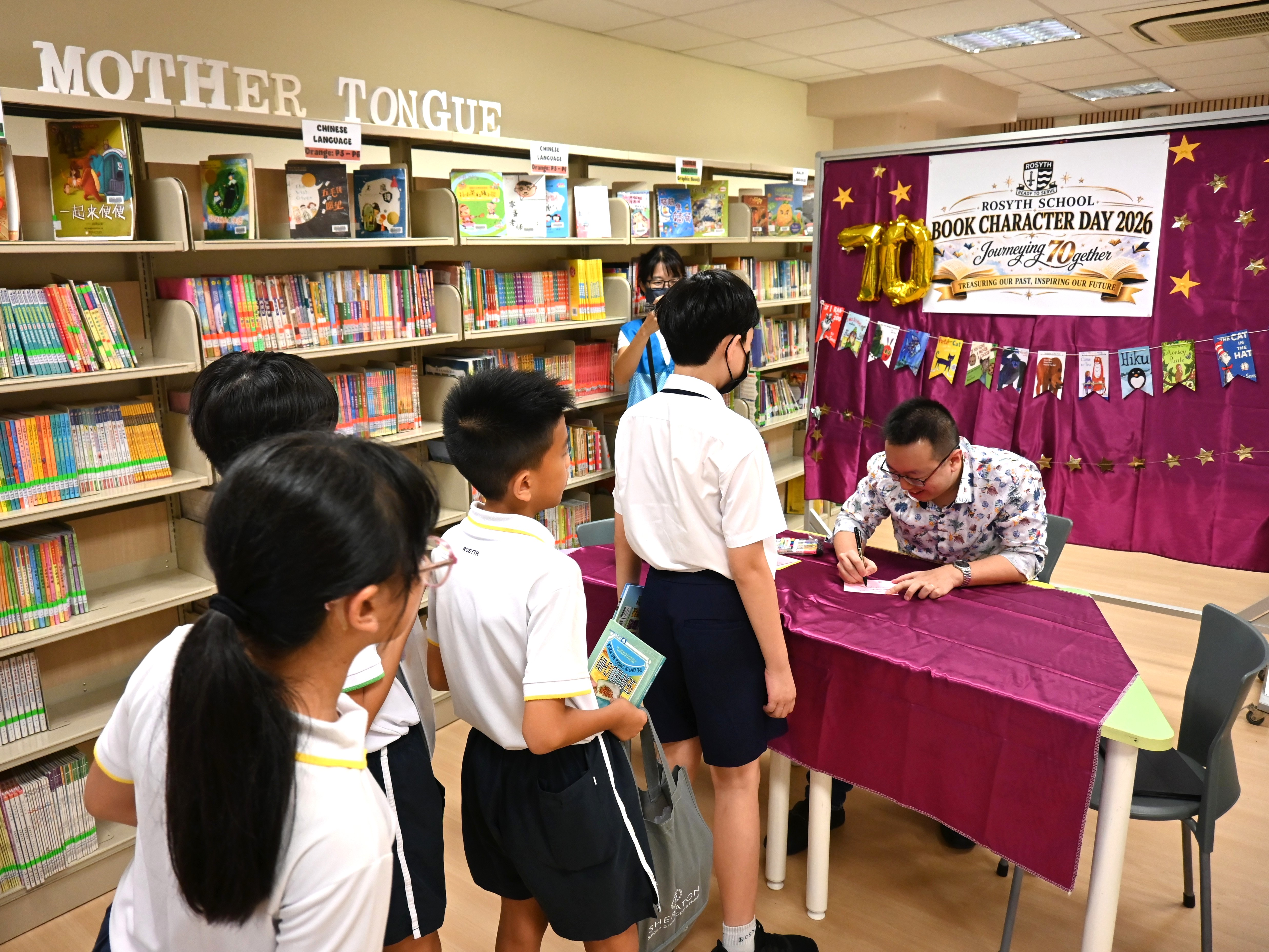 Author and speaker Shawn Seah autographing books and cards for students in the school library. 